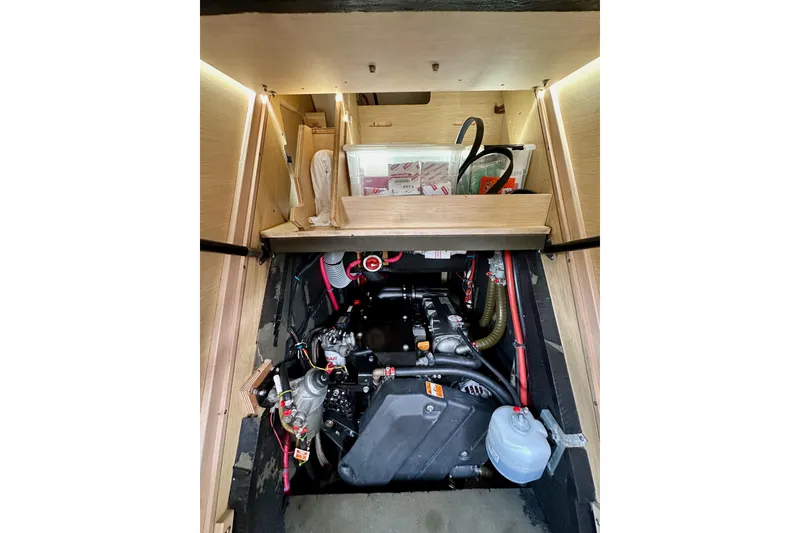 Slide: The Image of Engine compartment of a 2018 Jeanneau 54 sailboat, showcasing mechanical components and storage. - 110