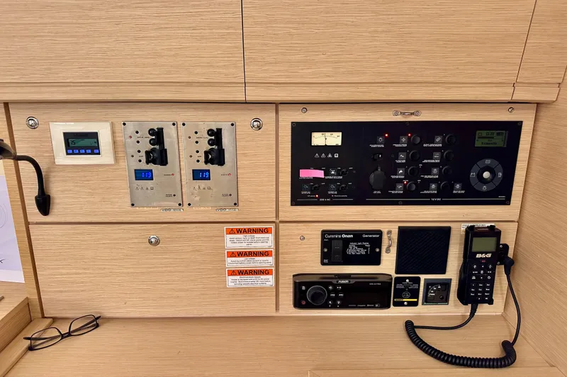 Slide: The Image of Control panel of a 2018 Jeanneau 54 yacht with various instruments and warning labels. - 66