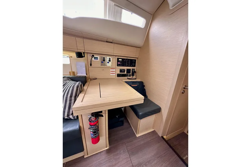 Slide: The Image of 2018 Jeanneau 54 yacht interior with navigation station, control panels, and seating area. - 65
