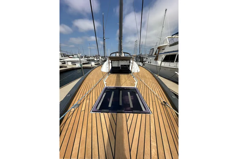 Slide: The Image of 2018 Jeanneau 54 yacht with teak deck, docked in marina under blue sky. - 51