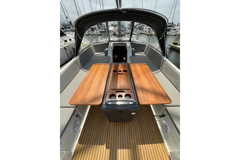 Slide: The Image of 2018 Jeanneau 54 yacht cockpit with wooden table and seating, docked at marina. - 58