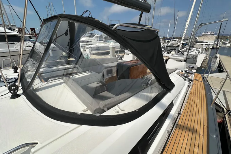 Slide: The Image of 2018 Jeanneau 54 sailboat with cockpit cover, docked at marina. - 56