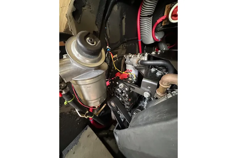 Slide: The Image of Engine compartment of a 2018 Jeanneau 54 sailboat, showcasing mechanical components and wiring. - 111