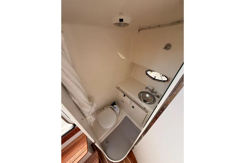 Slide: The Image of Compact bathroom in 2005 Tiara Yachts 2900 Open Classic, featuring toilet, sink, and porthole. - 51