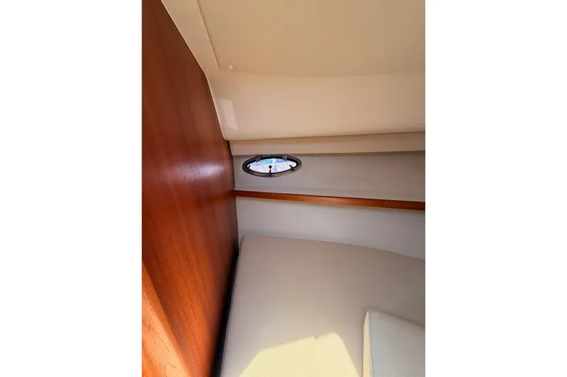 Slide: The Image of Interior cabin of 2005 Tiara Yachts 2900 Open Classic, featuring wood paneling and a porthole. - 69