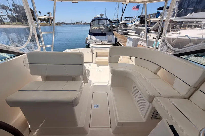 Slide: The Image of 2005 Tiara Yachts 2900 Open Classic interior with white seating, docked at marina. - 73