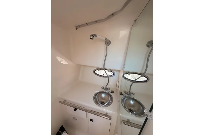 Slide: The Image of Interior of 2005 Tiara Yachts 2900 Open Classic, featuring a compact bathroom with sink and mirror. - 54