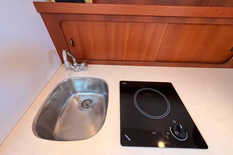Slide: The Image of 2005 Tiara Yachts 2900 Open Classic galley with sink and electric cooktop. - 50