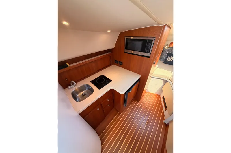 Slide: The Image of 2005 Tiara Yachts 2900 Open Classic interior kitchen with sink, stove, and microwave. - 46