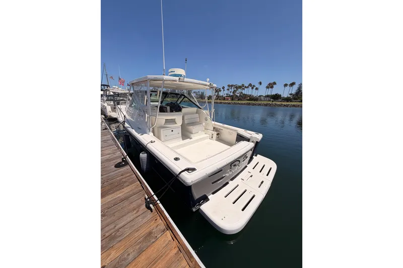 Slide: The Image of 2005 Tiara Yachts 2900 Open Classic docked, showcasing spacious deck and sleek design. - 7