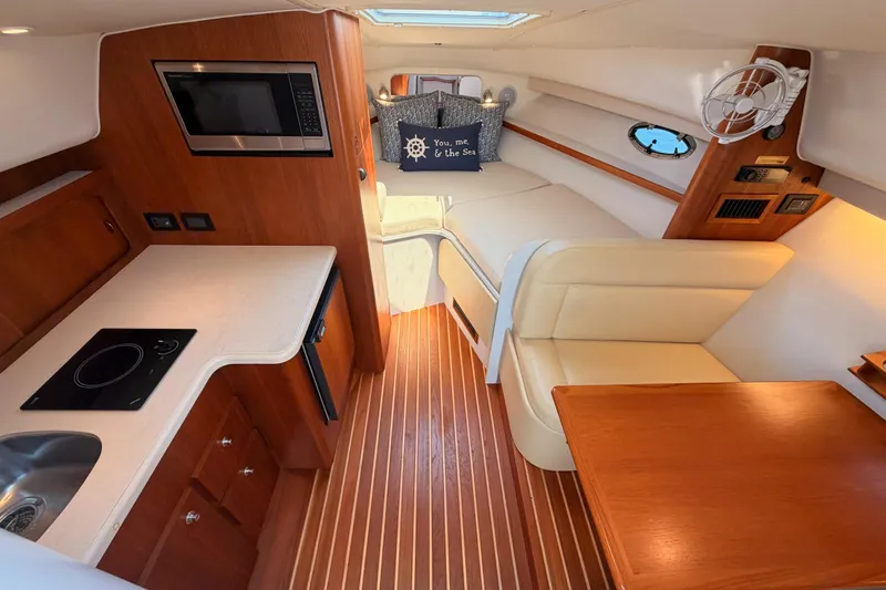 Slide: The Image of 2005 Tiara Yachts 2900 Open Classic interior with kitchenette, seating, and wood accents. - 45