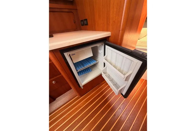 Slide: The Image of Open mini fridge in 2005 Tiara Yachts 2900 Open Classic, showcasing wooden interior. - 49