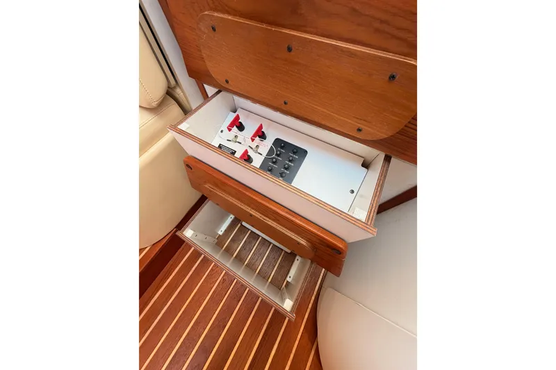 Slide: The Image of Control panel in 2005 Tiara Yachts 2900 Open Classic, featuring wooden cabinetry and switches. - 56
