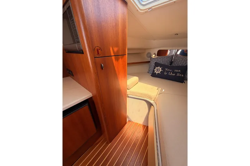 Slide: The Image of Interior of 2005 Tiara Yachts 2900 Open Classic, featuring wood cabinetry and cozy seating. - 65