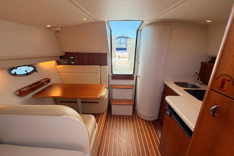 Slide: The Image of 2005 Tiara Yachts 2900 Open Classic interior with dining area and kitchenette. - 71
