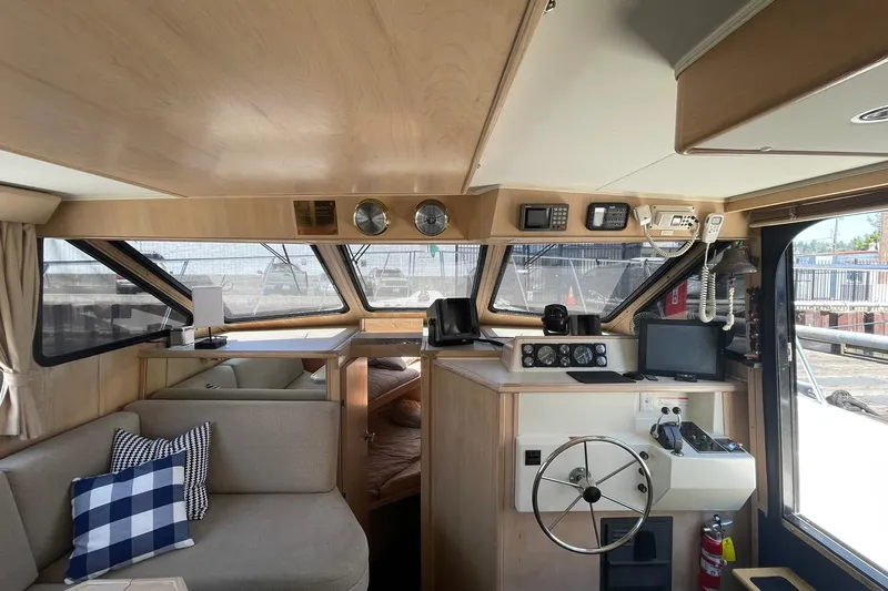 Slide: The Image of Interior of a 1990 Tollycraft 34 Sport Sedan boat, featuring helm and seating area. - 1