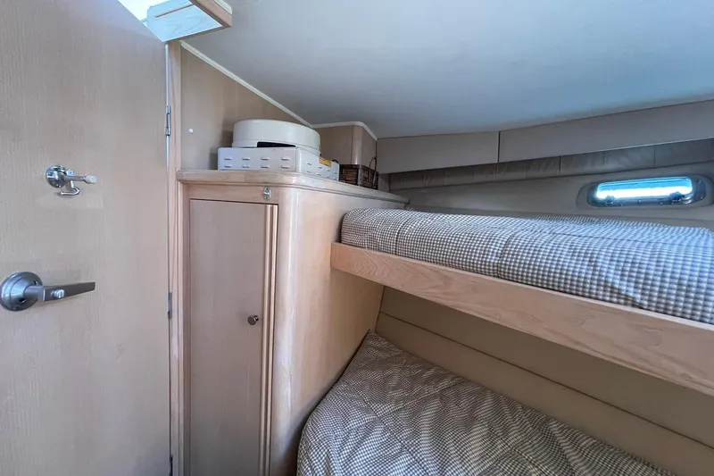 Slide: The Image of 1990 Tollycraft 34 Sport Sedan cabin with bunk beds and storage. - 17
