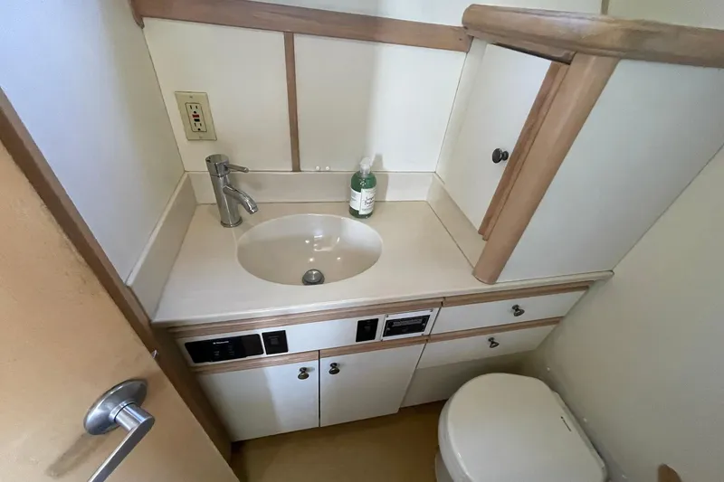 Slide: The Image of Bathroom interior of 1990 Tollycraft 34 Sport Sedan with sink and storage cabinets. - 13
