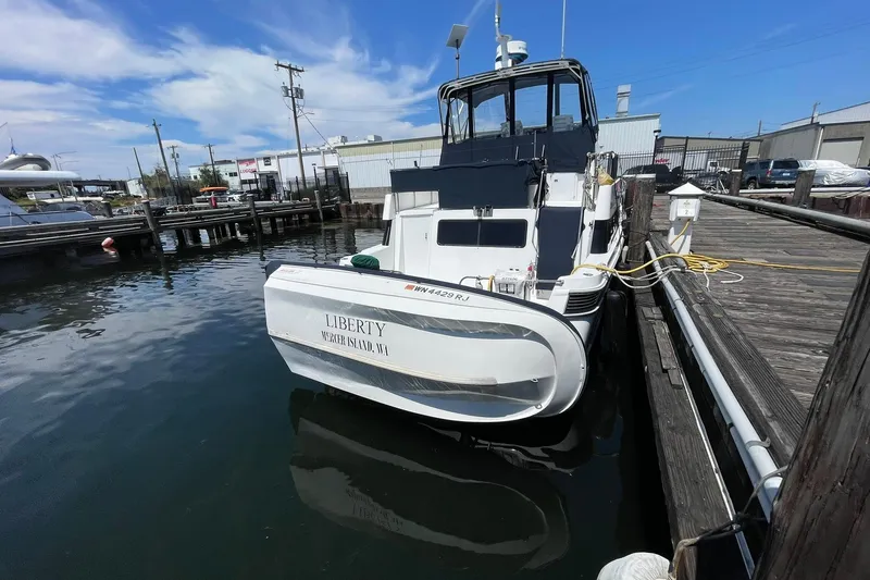 Slide: The Image of 1990 Tollycraft 34 Sport Sedan docked at marina under blue sky. - 54