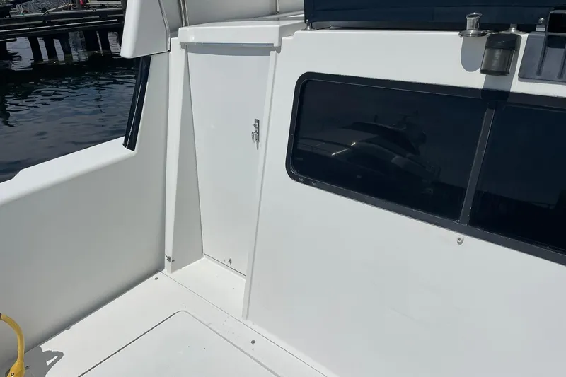 Slide: The Image of 1990 Tollycraft 34 Sport Sedan boat deck with white exterior and window. - 48