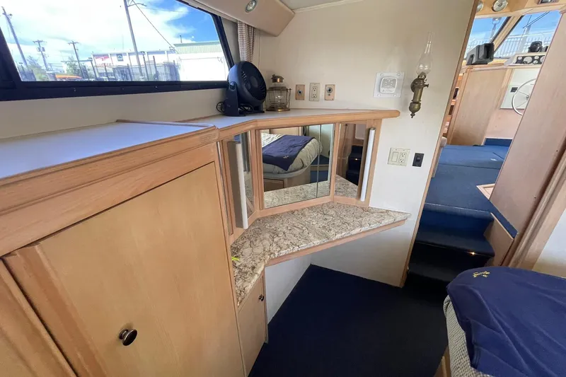 Slide: The Image of 1990 Tollycraft 34 Sport Sedan interior with wood cabinetry and mirrored vanity. - 10