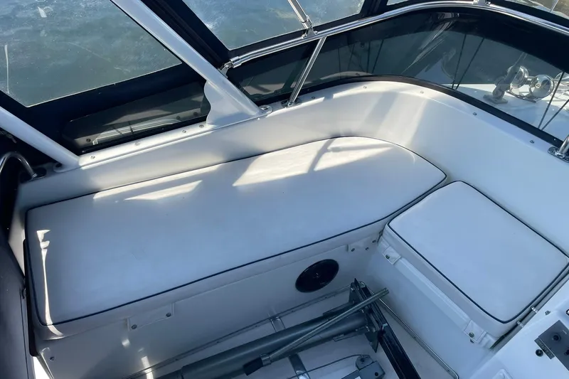 Slide: The Image of 1990 Tollycraft 34 Sport Sedan interior seating with white cushions and windows. - 44