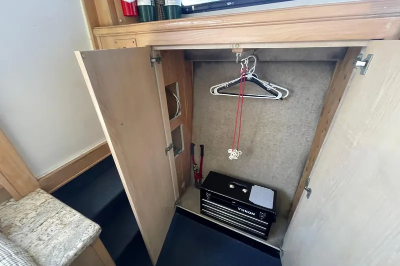 Slide: The Image of 1990 Tollycraft 34 Sport Sedan interior closet with hangers and toolbox. - 11