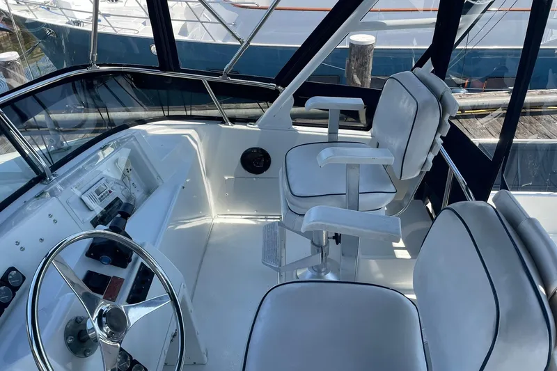 Slide: The Image of 1990 Tollycraft 34 Sport Sedan helm with white seating and steering wheel. - 42