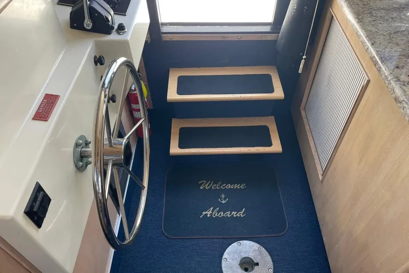 Slide: The Image of Interior of 1990 Tollycraft 34 Sport Sedan with steering wheel and welcome mat. - 38