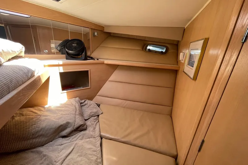 Slide: The Image of 1990 Tollycraft 34 Sport Sedan cabin interior with cozy bedding and wooden paneling. - 16