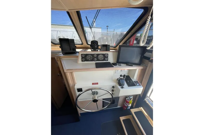 Slide: The Image of 1990 Tollycraft 34 Sport Sedan helm with steering wheel, navigation equipment, and control panel. - 26