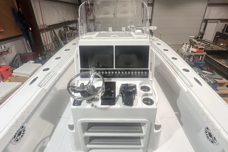 Slide: The Image of 2022 Costa Custom Boats 264HC helm with steering wheel and control panel in a workshop. - 9