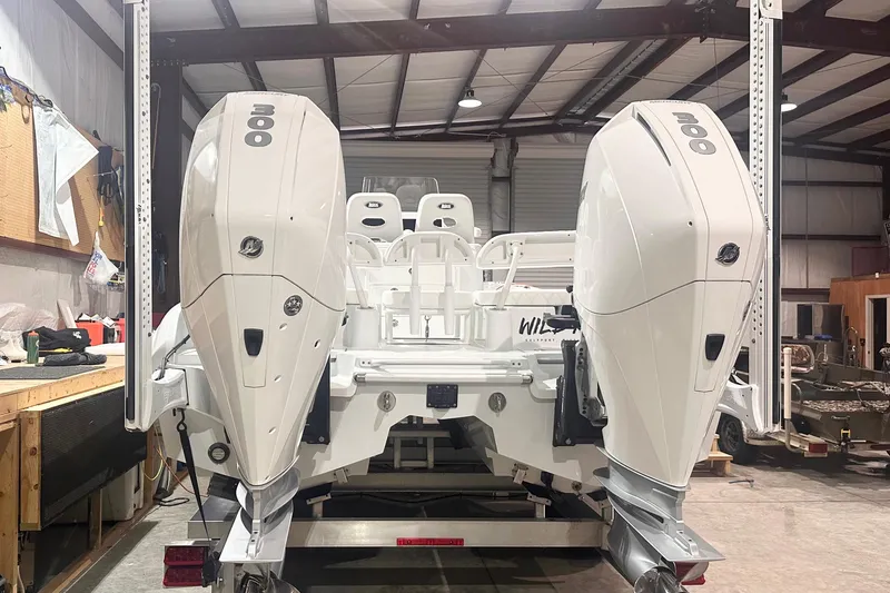 Slide: The Image of 2022 Costa Custom Boats 264HC with dual 300 horsepower engines in a workshop setting. - 4