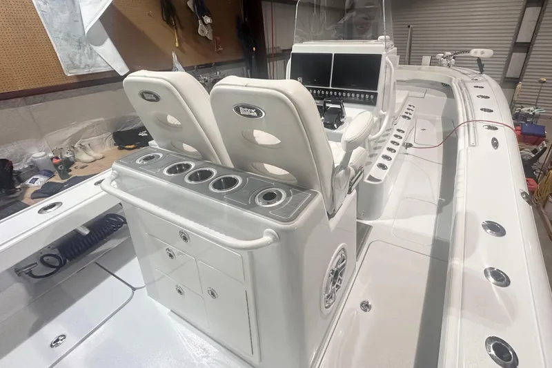 Slide: The Image of 2022 Costa Custom Boats 264HC interior with dual seats and control panel in a workshop setting. - 10