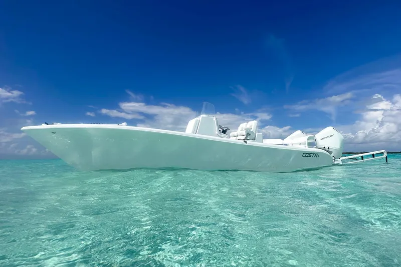 Slide: The Image of 2022 Costa Custom Boats 264HC on clear turquoise water under a vibrant blue sky. - 7