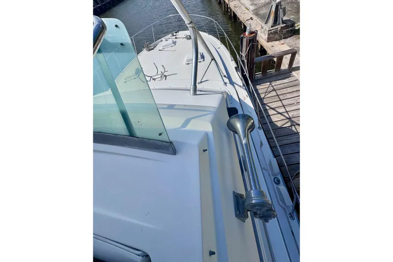 Slide: The Image of 1986 Bertram 46III Convertible yacht docked, showcasing deck and railing details. - 28