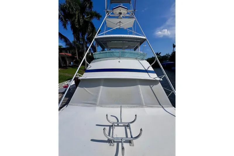 Slide: The Image of 1986 Bertram 46III Convertible yacht with tower, docked under clear blue sky. - 48