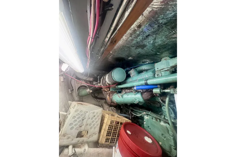 Slide: The Image of Engine room of a 1986 Bertram 46III Convertible boat, showing machinery and storage crates. - 67