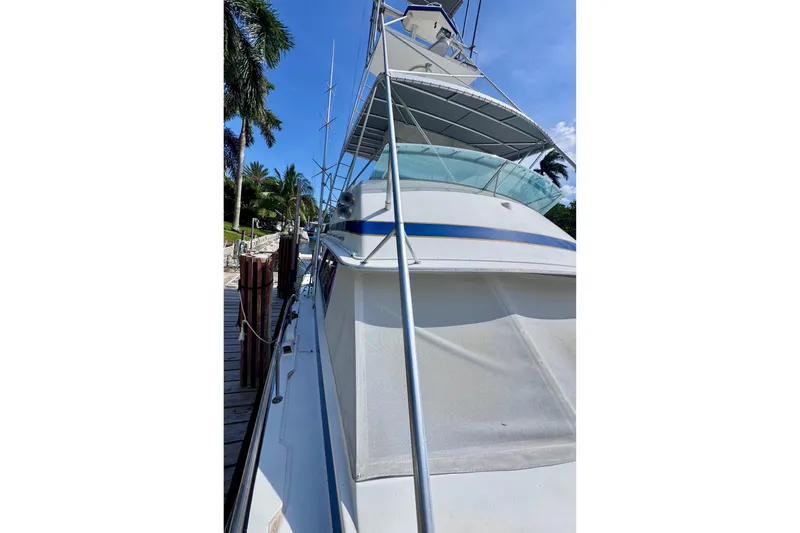 Slide: The Image of 1986 Bertram 46III Convertible yacht docked, showcasing sleek design and spacious deck. - 50