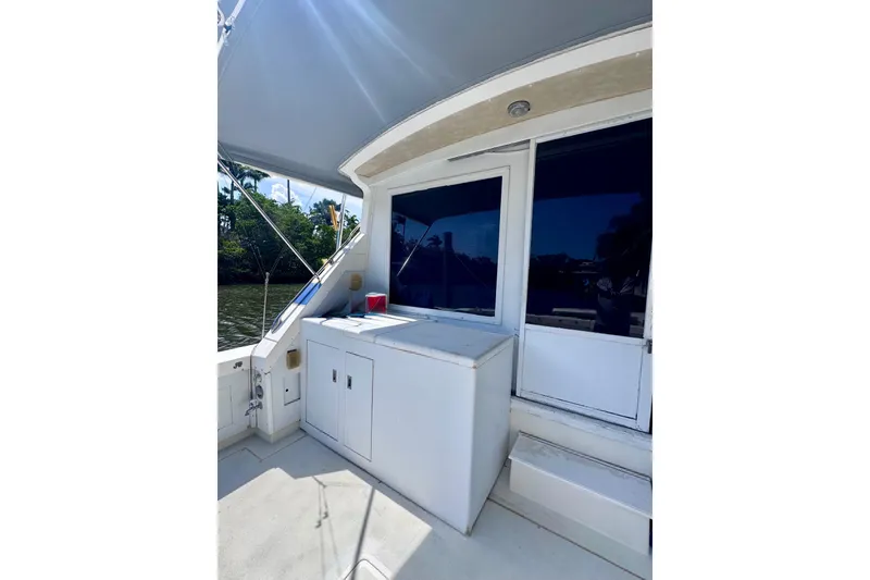 Slide: The Image of 1986 Bertram 46III Convertible yacht deck with storage cabinets and shaded seating area. - 7