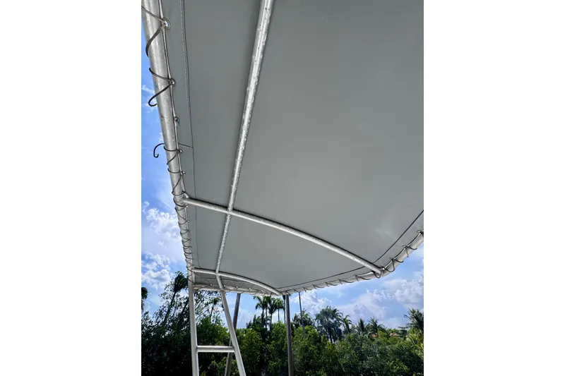 Slide: The Image of 1986 Bertram 46III Convertible boat canopy with metal frame against a blue sky. - 44
