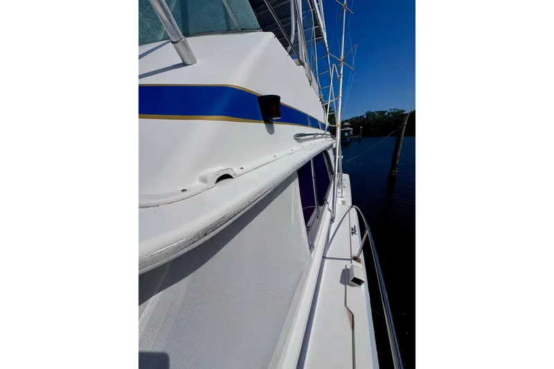 Slide: The Image of 1986 Bertram 46III Convertible yacht side view, featuring sleek white design and blue accents. - 46