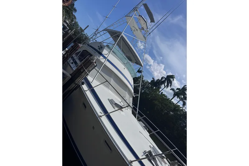Slide: The Image of 1986 Bertram 46III Convertible yacht docked under a clear blue sky. - 4