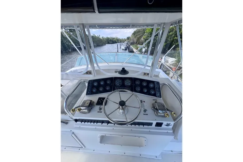 Slide: The Image of Cockpit view of 1986 Bertram 46III Convertible yacht, featuring steering wheel and control panel. - 13