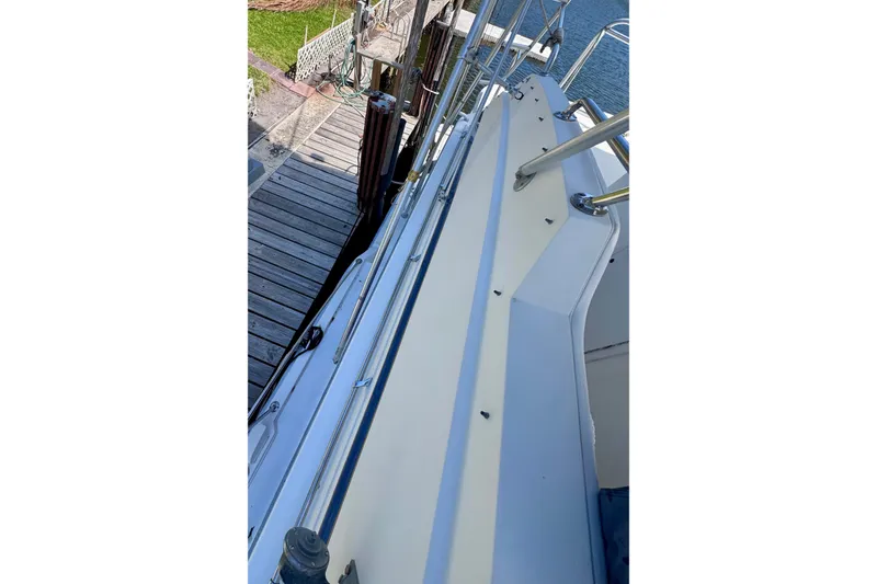 Slide: The Image of Side view of 1986 Bertram 46III Convertible yacht docked by wooden pier. - 29