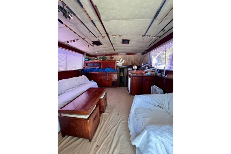 Slide: The Image of Interior of a 1986 Bertram 46III Convertible yacht with sofas and fishing rods. - 53
