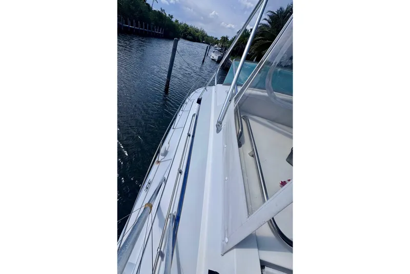Slide: The Image of 1986 Bertram 46III Convertible yacht docked on a calm waterway. - 18