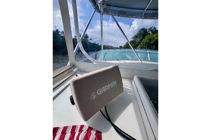 Slide: The Image of 1986 Bertram 46III Convertible boat with Garmin equipment, cruising on a scenic river. - 17