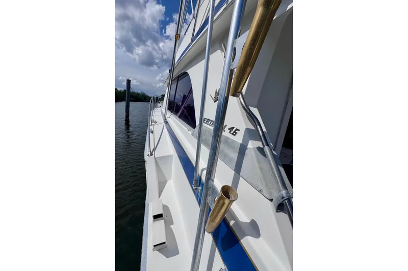 Slide: The Image of Side view of a 1986 Bertram 46III Convertible yacht docked by the water. - 45