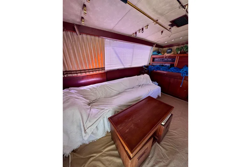 Slide: The Image of Interior of 1986 Bertram 46III Convertible yacht with sofa and wooden table. - 54